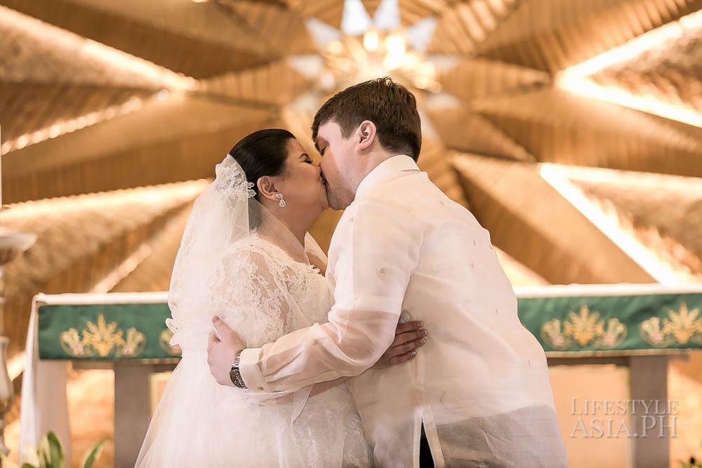 The bride and groom during their first kiss