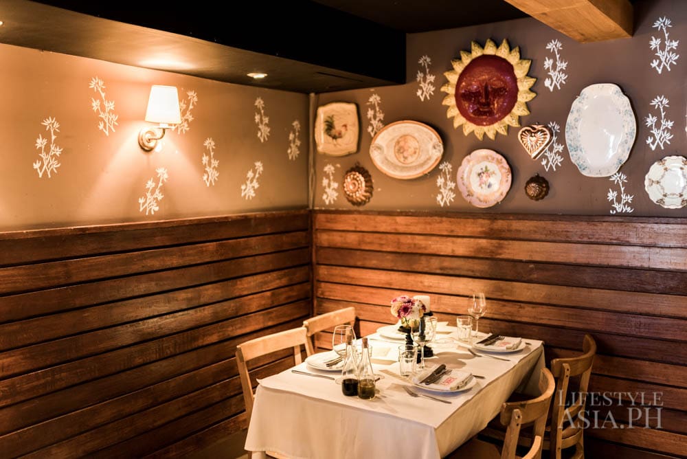 A simple table setting of white linens, plates and small flower arrangements allow food to become the centerpiece