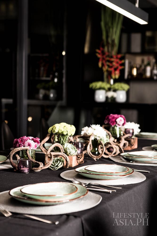 Fresh flowers brighten the table setting amidst a space inspired by Brutalism