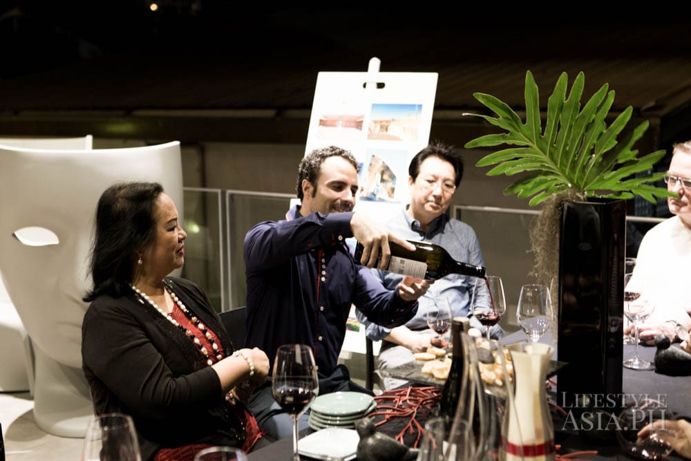 Besay Gonzalez of AWC Philippines / Txanton explains the evening selection of wines to Tita Trillo and Jess Montemayor, Driado chairs are in the background