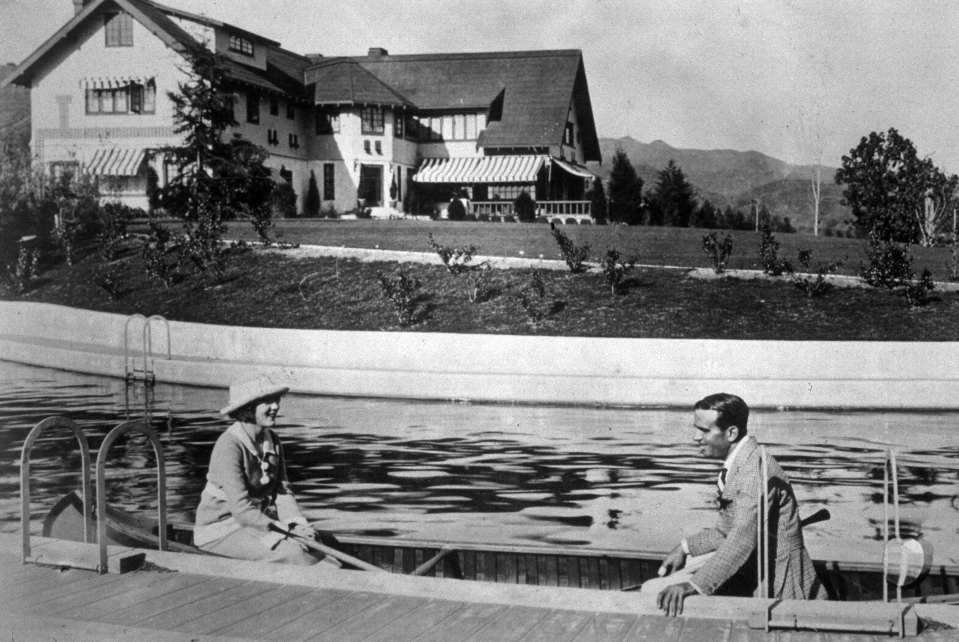 Mary Pickford and Douglas Fairbanks in a canoe in their swimming pool