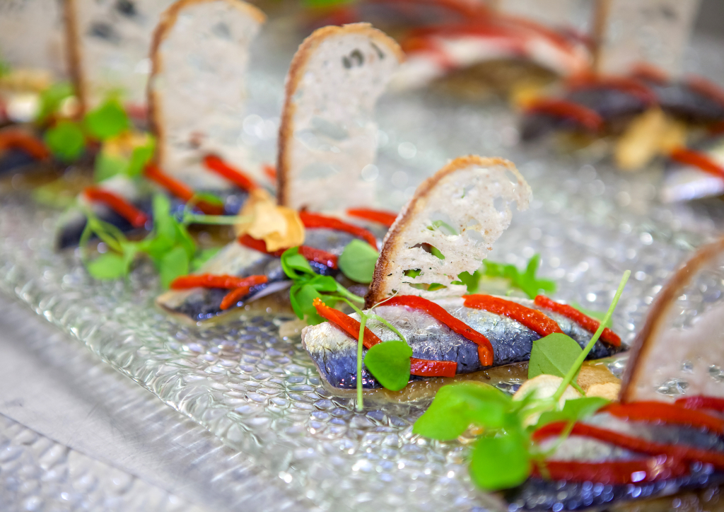 Marinated sardines on sourdough with braised aubergine and garlic chips
