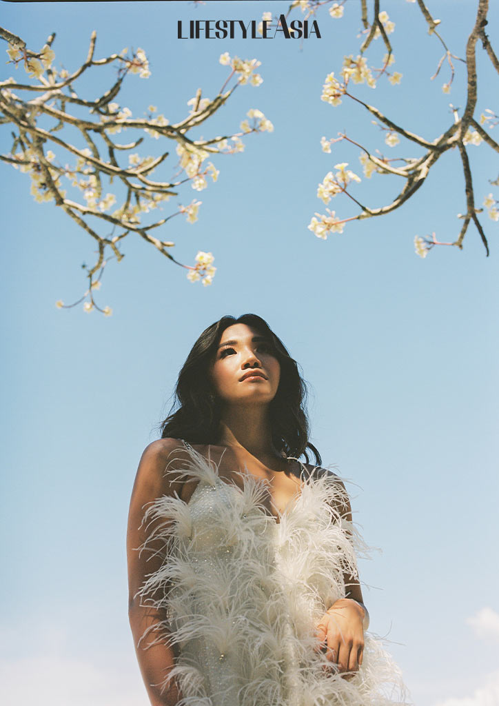 Sunlight Air's chief executive is wearing White ostrich feather dress by Julianne Syjuco, diamond earrings by Mei Diamond Jewelry.
