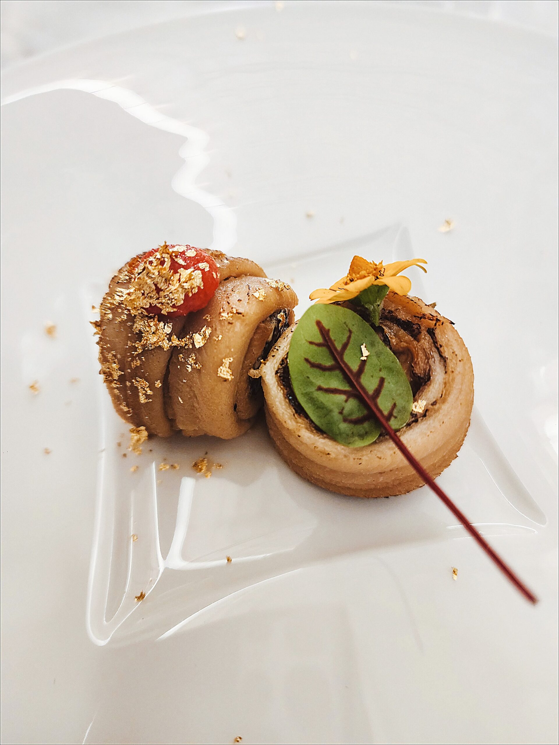 Cream cheese, black seaweed and salt water eel roll with spiced pollock roe, gold leaf and sakura flower