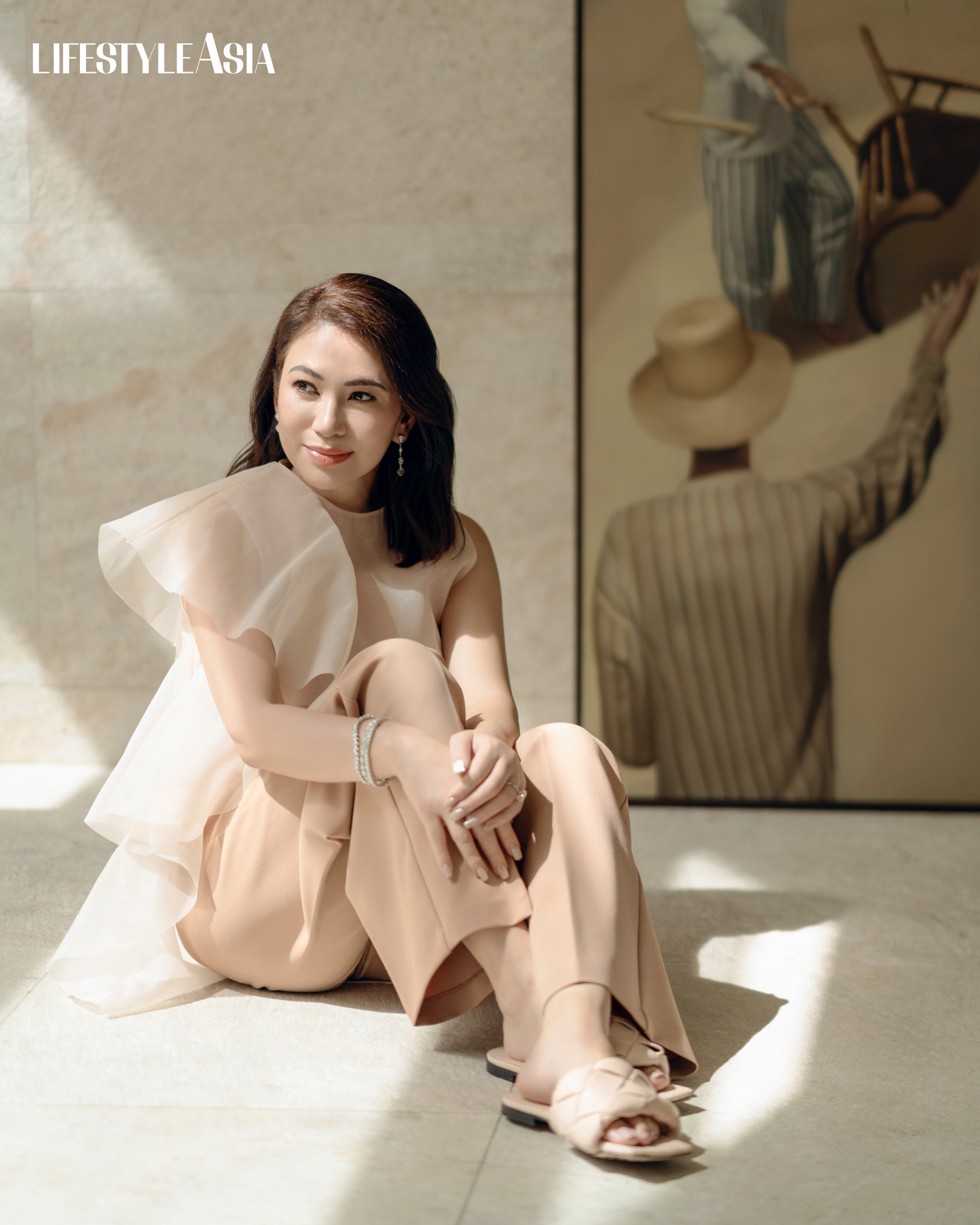 Ecru silk organza top with ruffle detail and trousers, VANIA ROMOFF; Beige Intrecciato slides, BOTTEGA VENETA; Diamond dangling earrings and tennis bracelets, JMA JEWELRY.