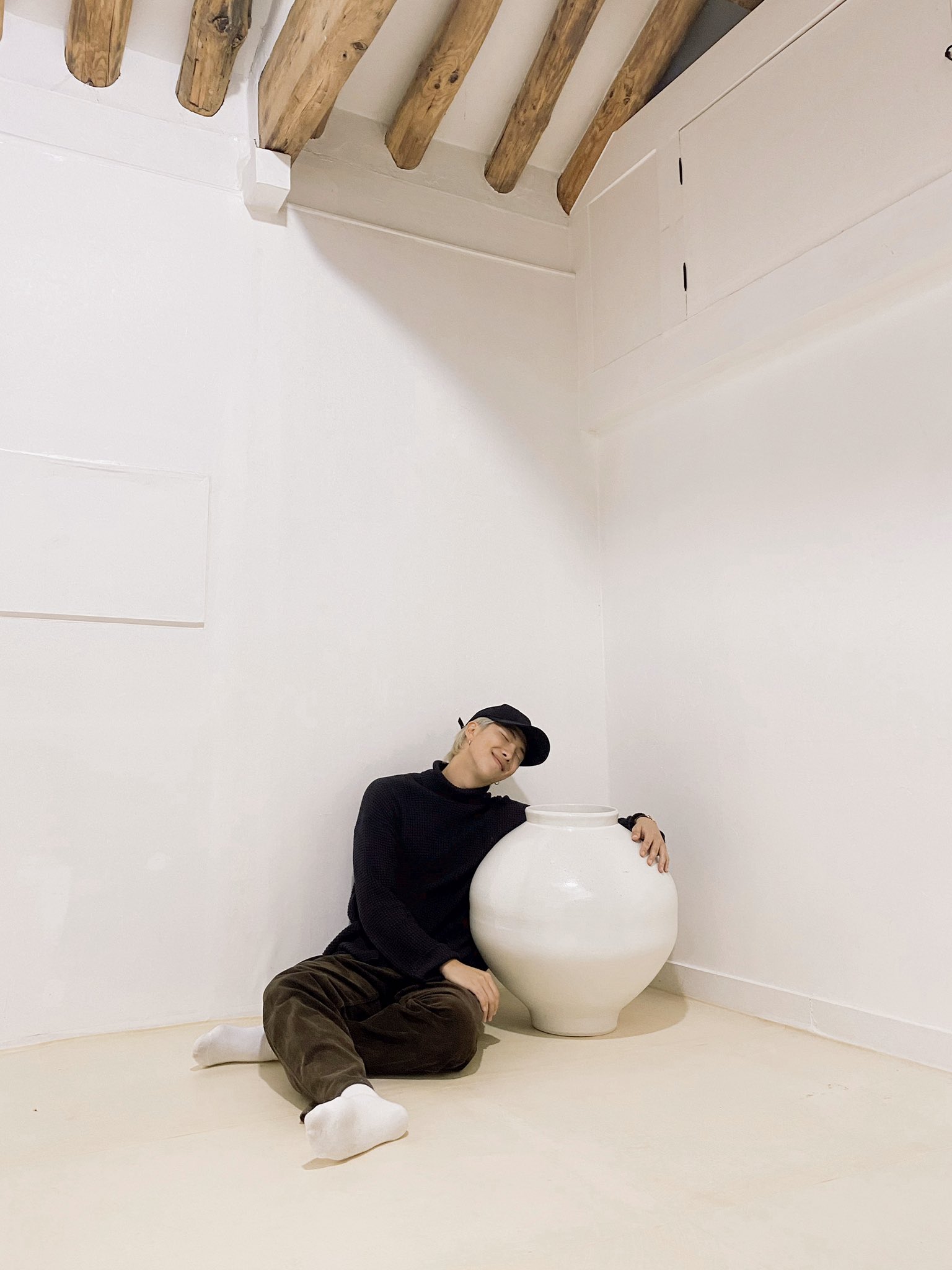 TS member RM posing with one of his Joseon dynasty moon jar 