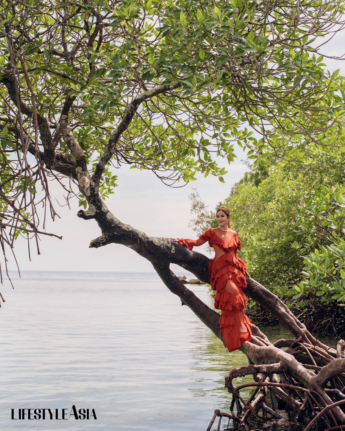 Burnt orange mesh long sleeved bookleaf dress, IVARLUSKI ASERON; Gold choker, Eskapularyo pendant attached to the Alaala necklace and wing earrings, ADAM PEREYRA.