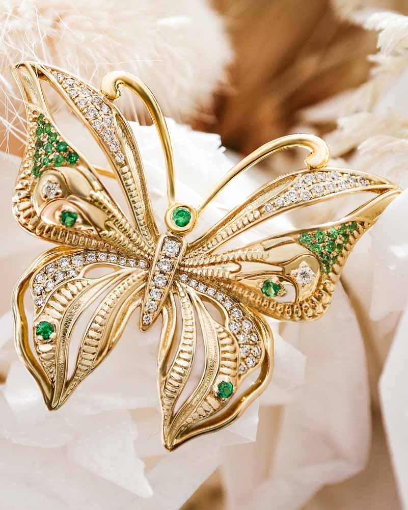 The Golden Butterfly Brooch with emerald gems and white diamonds