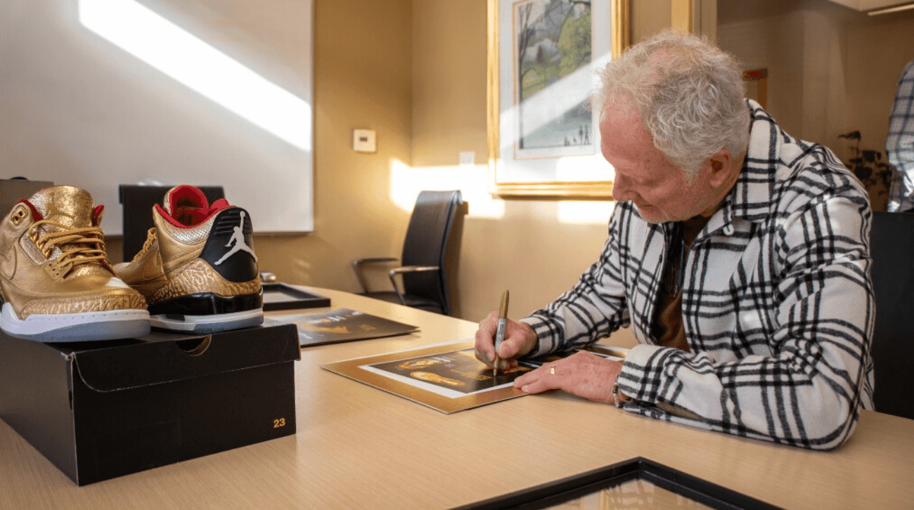 Tinker Hatfield signs the memorabilia that came with the gold Air Jordan 3