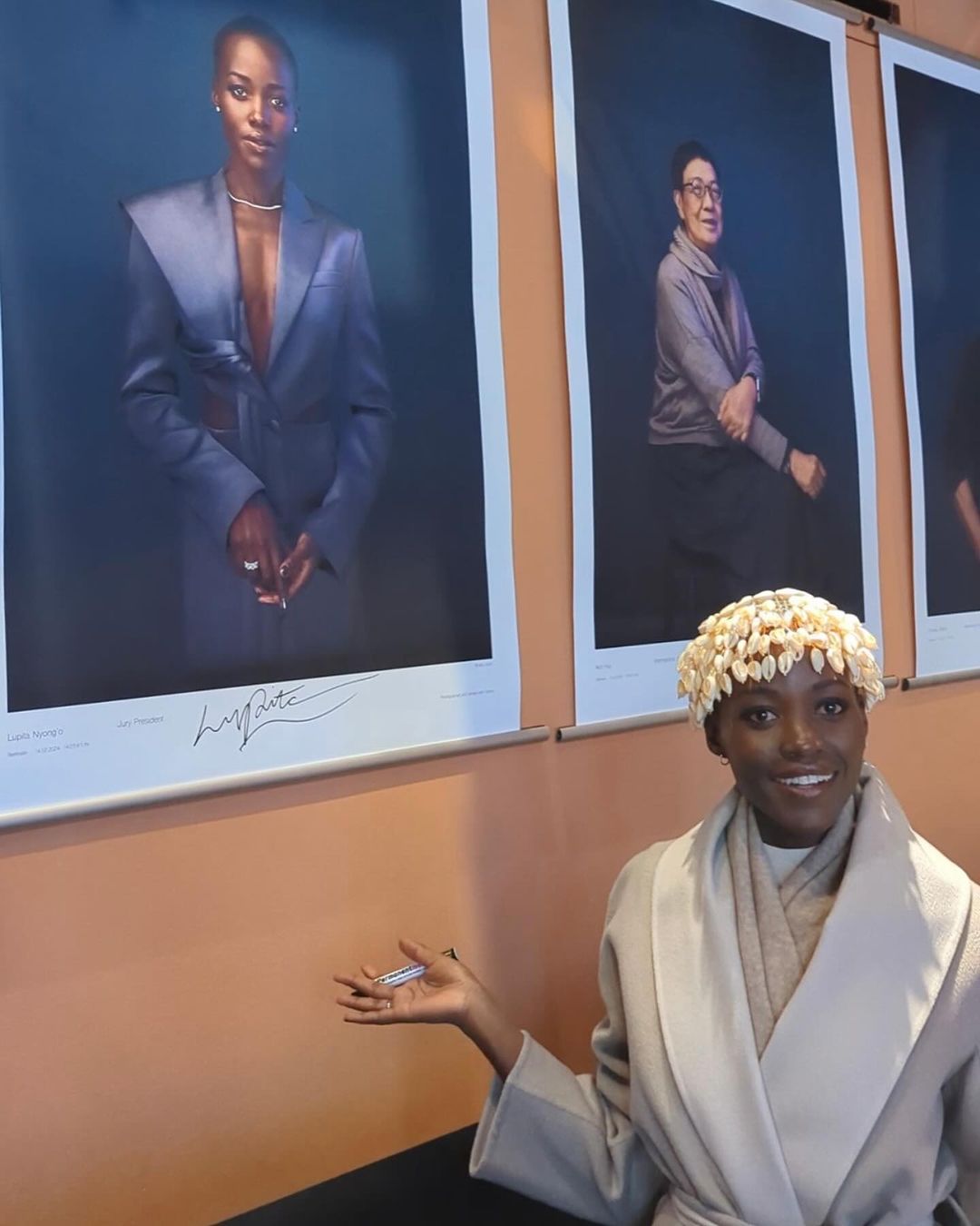 Lupita Nyong’o posing in front of her official Berlinale portrait, marking the first time a Black individual has ever held the position