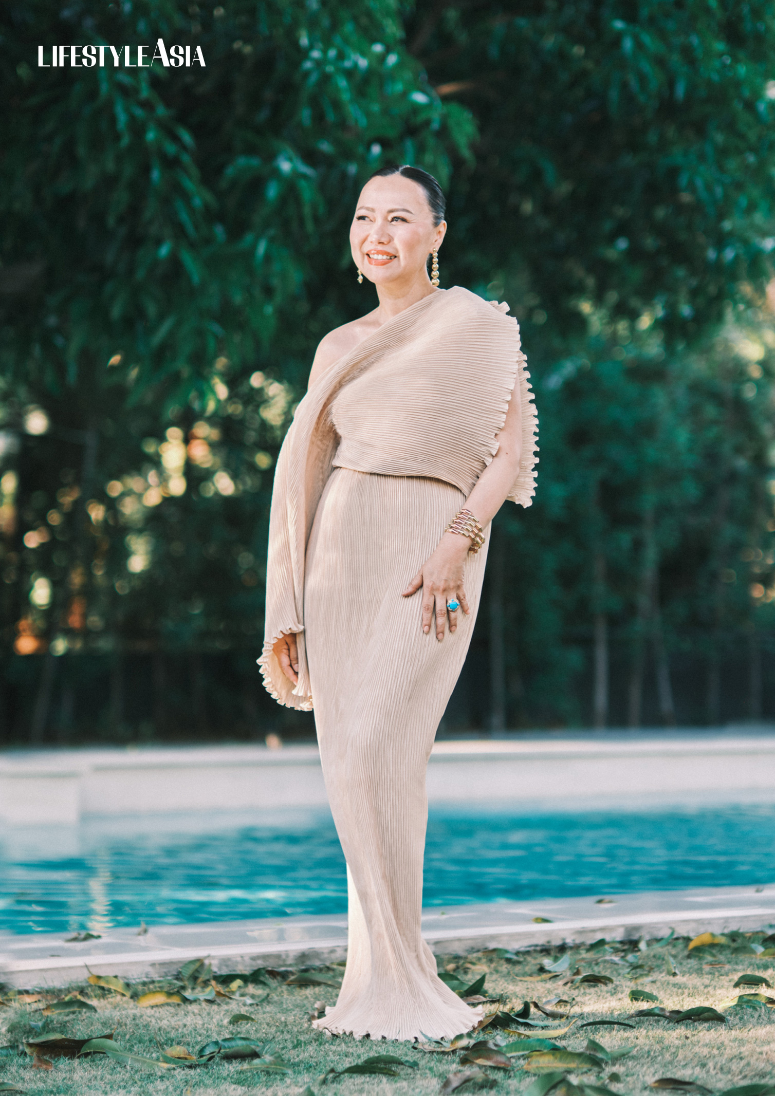 Beige plissé asymmetric column dress, HOUSE OF LAUREL; Gold drop earrings, and cuff, RIQUEZA; Turquoise cocktail ring, JUL B DIZON JEWELLERY