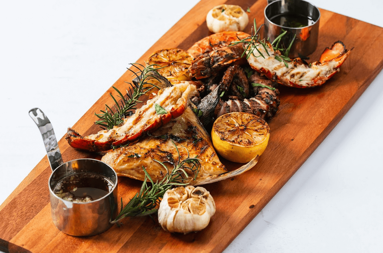TOP LEFT: Squid Ink Paella with Seafood; TOP RIGHT: Seafood Platter (Maine Lobster, Pulpo, Prawn and Hamachi Collar); BOTTOM LEFT: Iberian Chicken; BOTTOM RIGHT: Duck Confit Adobo a la Orange