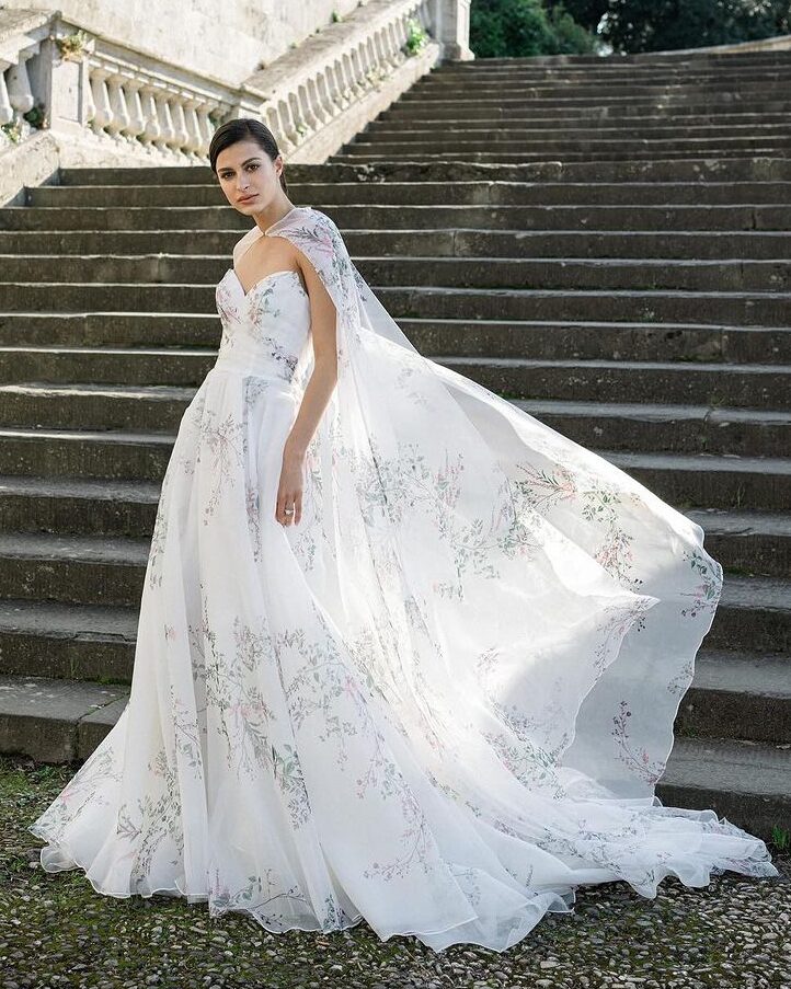 A dress with floral patterns and a cape