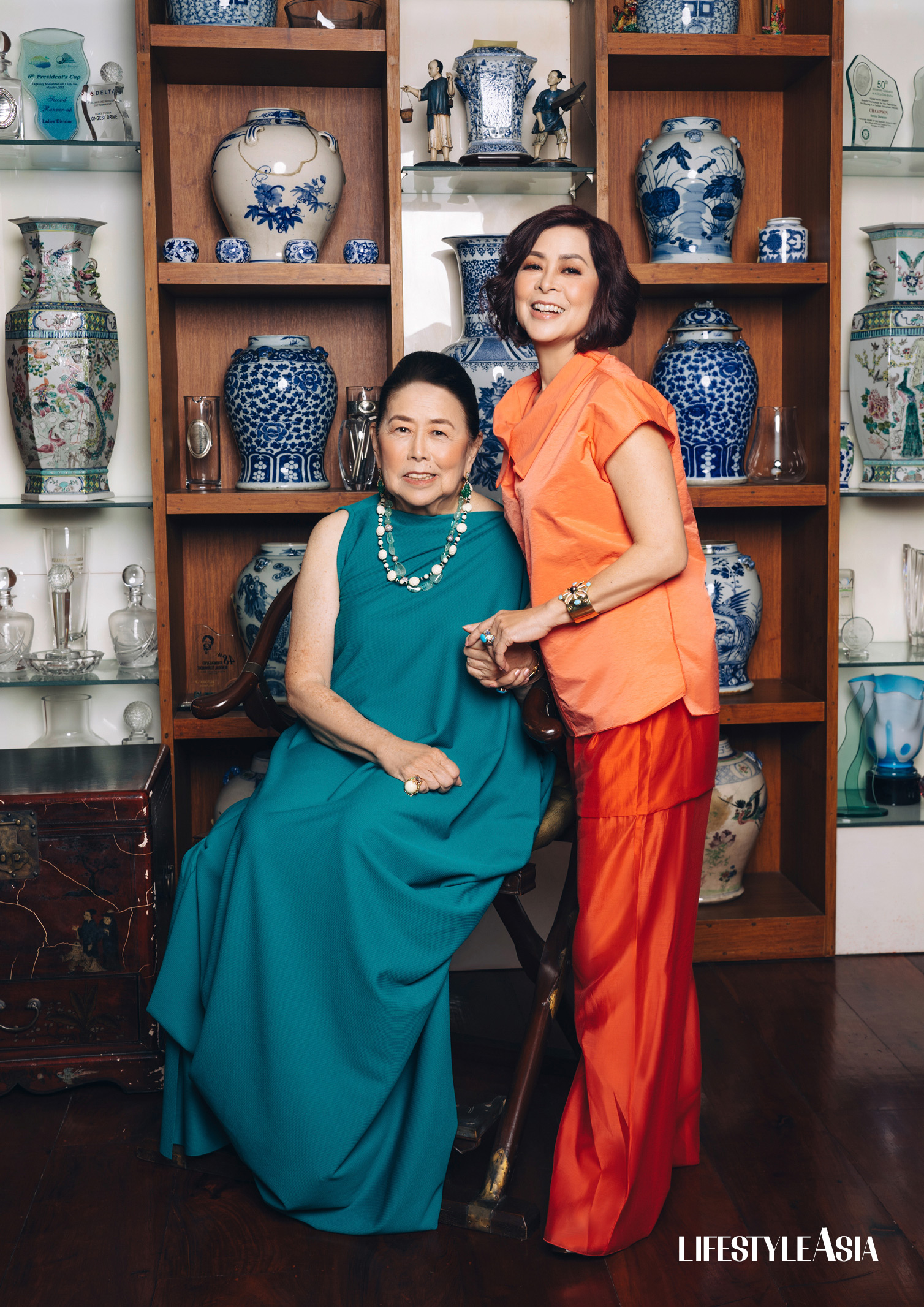 On Marixi: Teal caftan, HOUSE OF LAUREL; Jewelry, JUL B. DIZON; On Tessa: Orange top and trousers, YOYA; Earrings and ring, JUL B DIZON.
