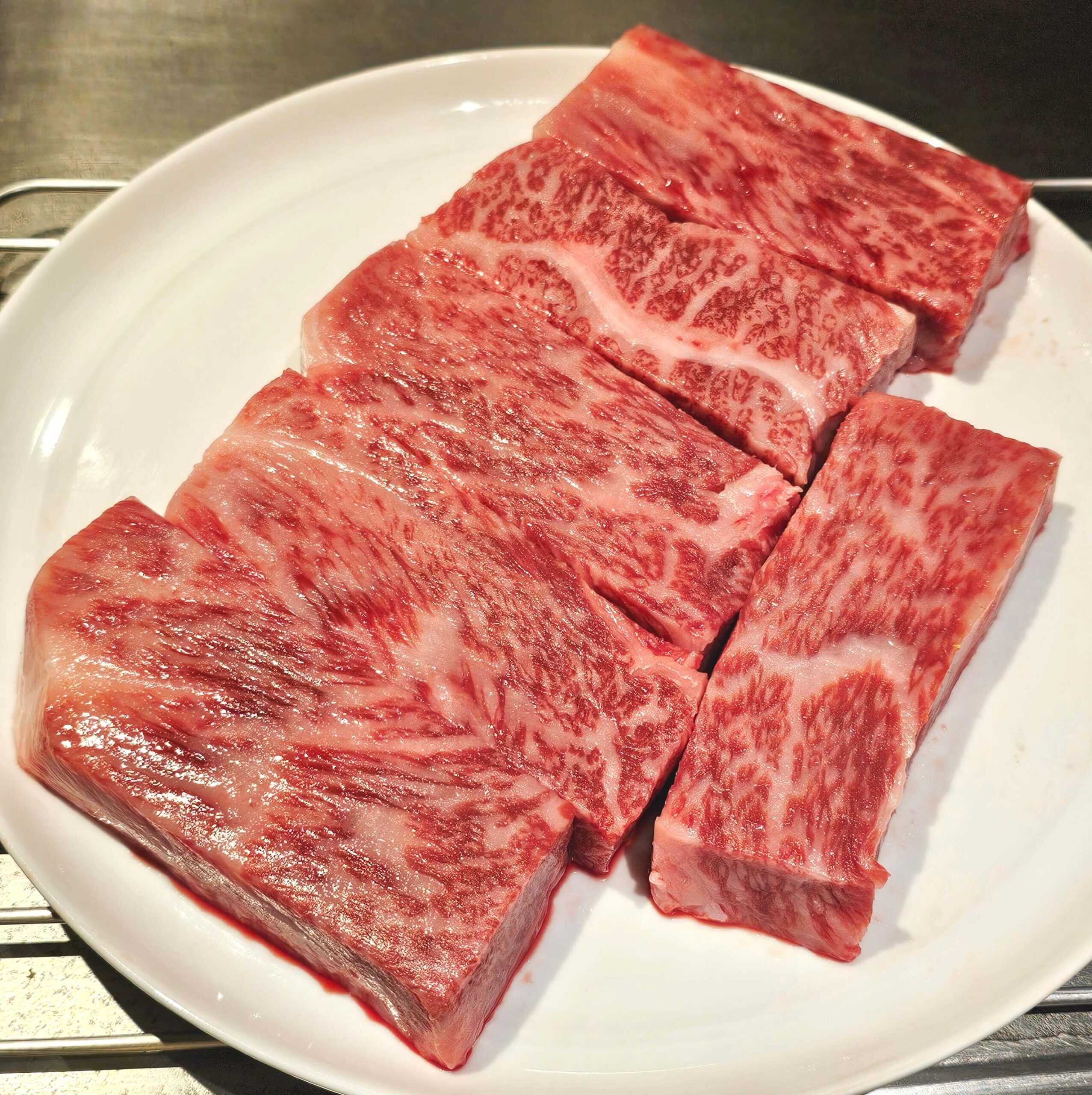 L-R, top to bottom: Japanese A5 Kagoshima Wagyu Sirloin with Fresh Wasabi and Garlic Chips; Norwegian Salmon Belly with Sautéed Avocado Seaweed and Fresh Wasabi Sauce; Lobster Sautéed with White Miso Vin Blanc Sauce with Local Vegetables; A5 Kagoshima Wagyu.