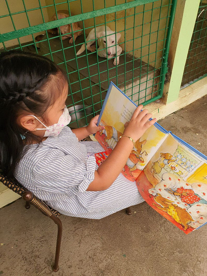 A child reading to a PAWS shelter dog for Project CALM