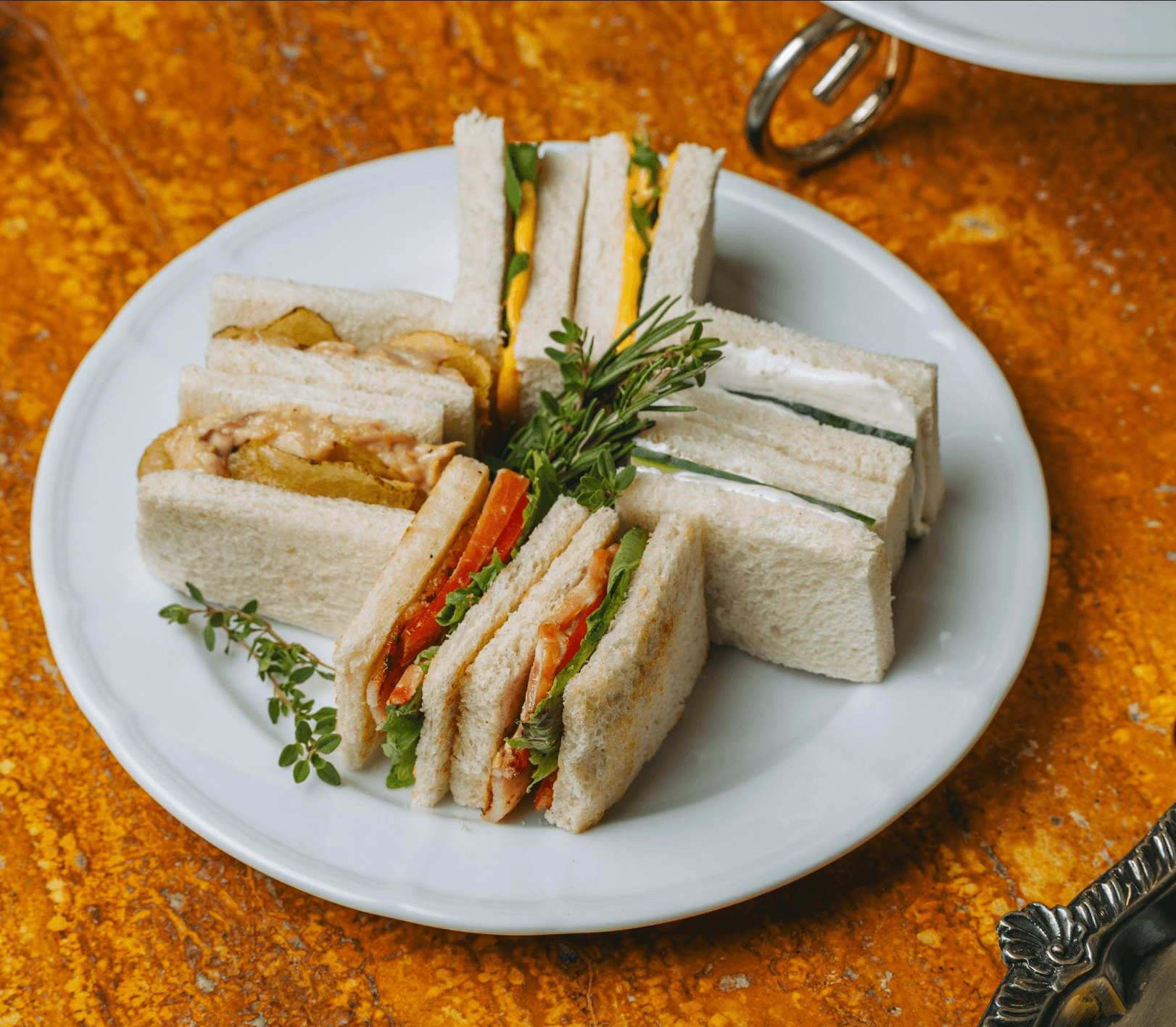 LEFT: English Breakfast Tea at Lusso. RIGHT: Finger sandwiches of goat cheese and cucumber; deviled egg and watercress; tuna with homemade mayonnaise and potato crisps; and pancetta, lettuce, and tomato.
