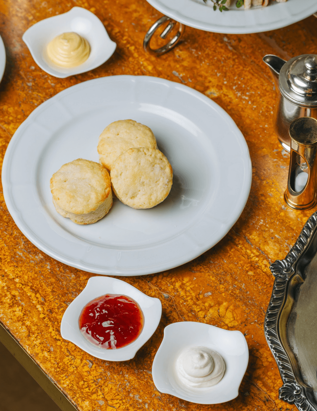 LEFT: Desserts (Mocha Sans Rival, Pecorino Cheesecake with Fresh Strawberries, Strawberry Prosecco tiramisù, and trio of fruit tarts finished with whipped cream). RIGHT: Scones with jam and clotted cream.