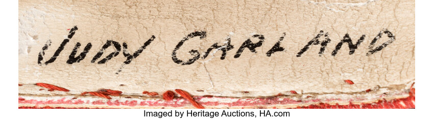 Judy Garland's name written in bold, black marker within the shoes