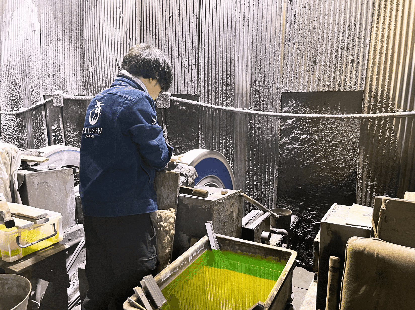 A blacksmith intently polishing a knife at Ryusen Hamono in Fukui