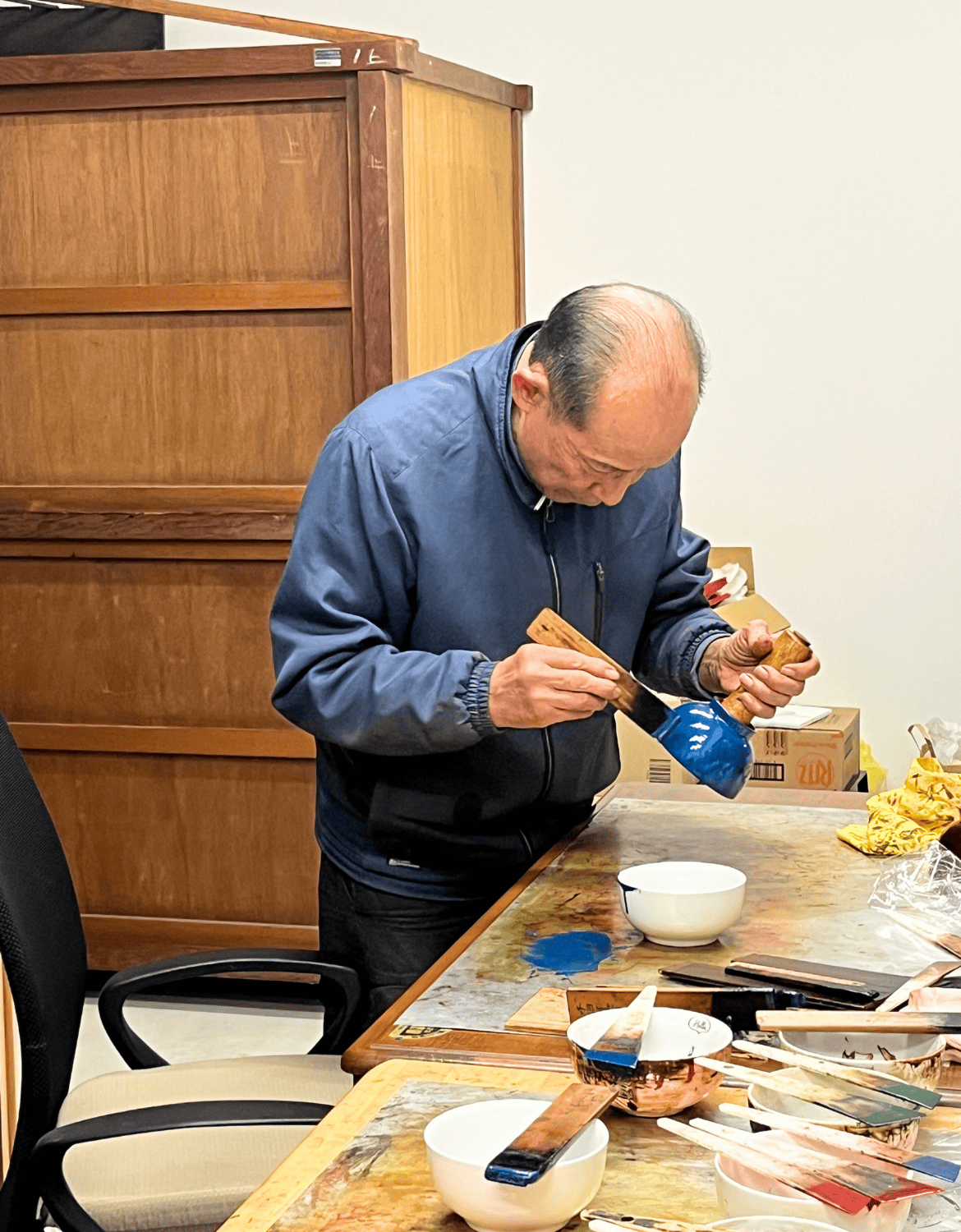 Mr. Kinkori demonstrates how to apply lacquer onto wooden bowls in Fukui Japan