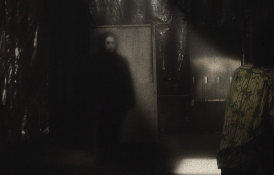 A still from the Japanese horror movie Pulse (2001), which presents a world where spirits try to invade through the internet