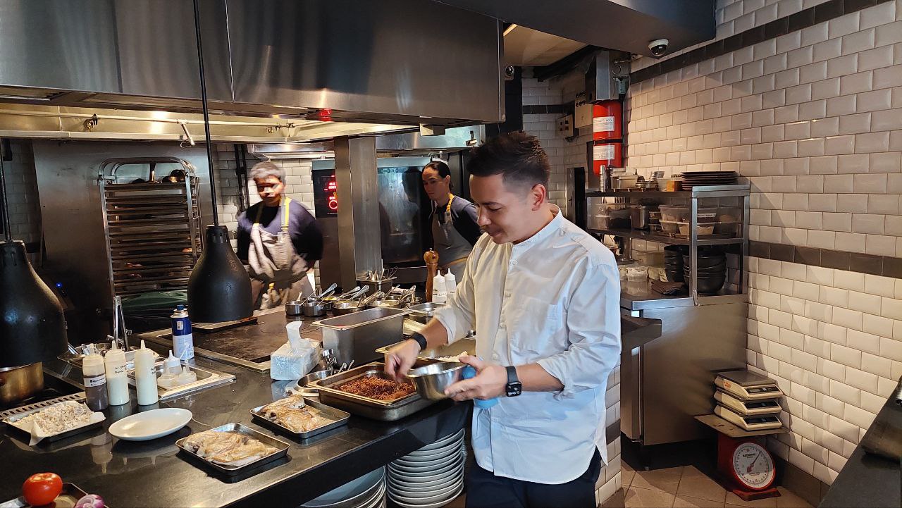 Chef Josh Boutwood showcasing the sous vide chicken and grains he prepared for the meal prep demonstration healthy meal prep