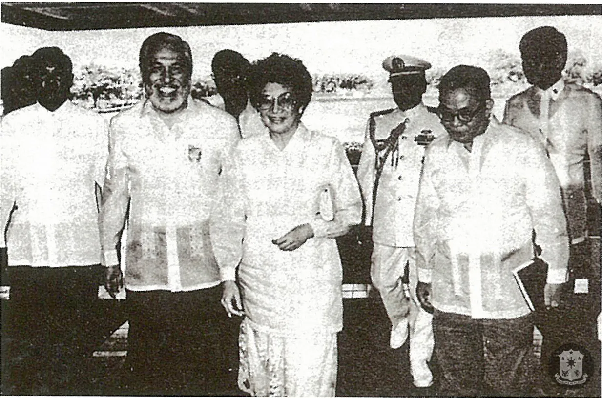 Corazon “Cory” Aquino wears a barong Filipino over her dress, joined by Speaker Ramon V. Mitra and Senate President Jovito Salonga in 1987