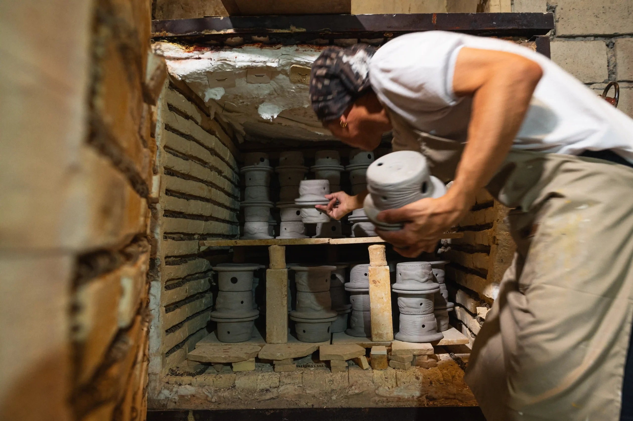 Each piece is carefully placed in the kiln for firing—a high-temperature process that hardens and strengthens the clay/Photo by Derrick Lim