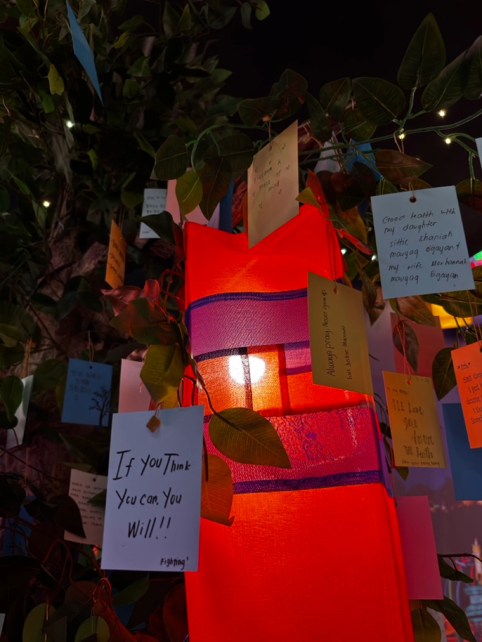 Wishes on paper and handmade lanterns hanging from the exhibition's Wishing Tree