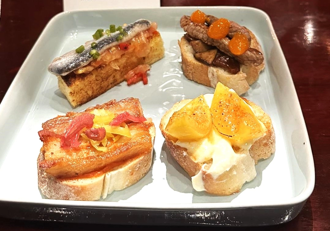 Caesar and Jamon Iberico Croquette; An assortment of pintxos: Boquerones, Grass-Fed Rib Eye, Pork Belly and Goat Cheese with Figs Compote; and Chicken and Chorizo Paella