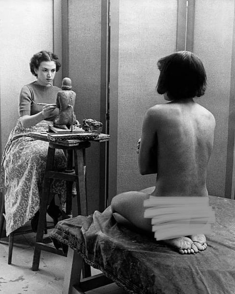 A woman poses for a sculptor