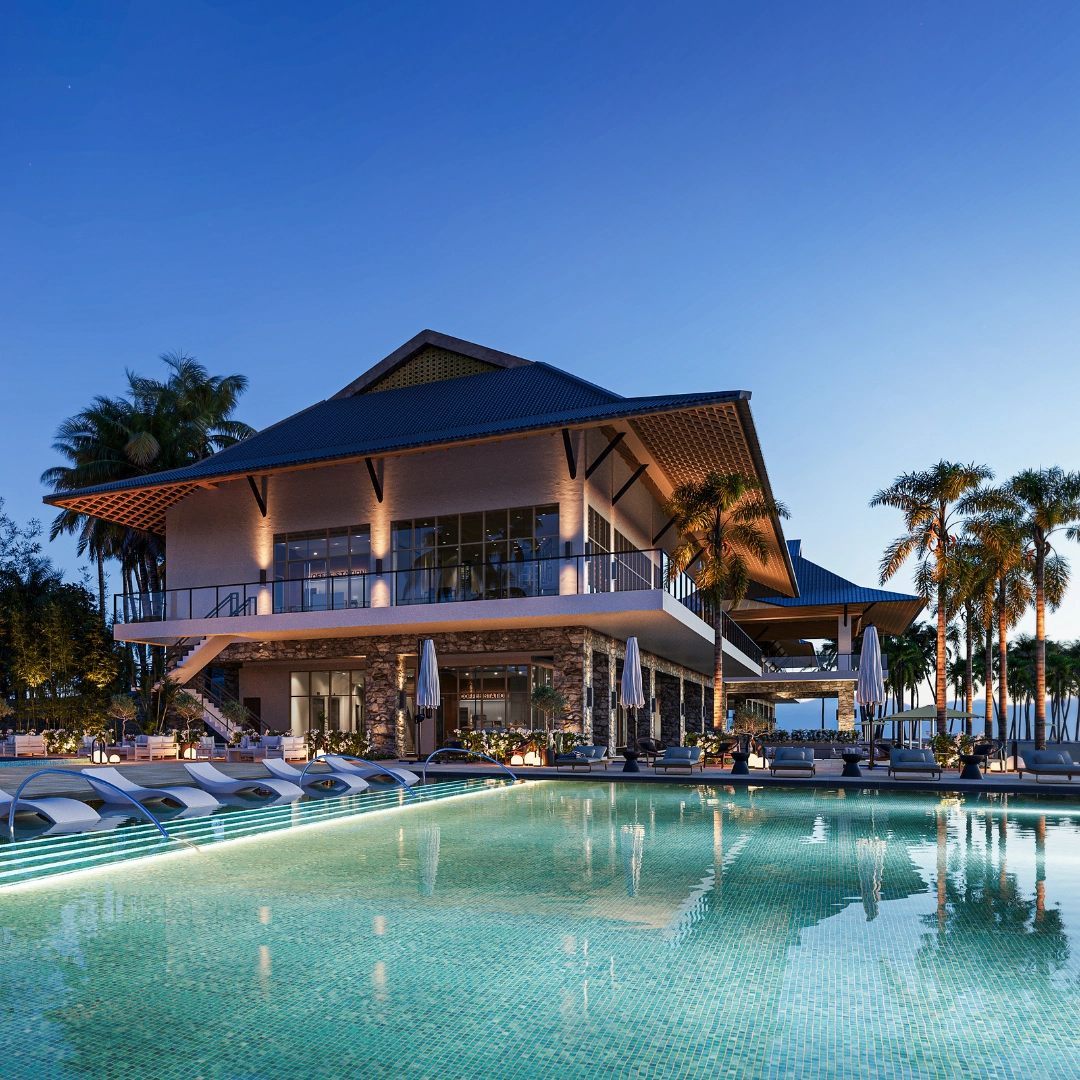 Luxury resort at dusk with a large illuminated pool, palm trees, and a two-story building with glass balconies.