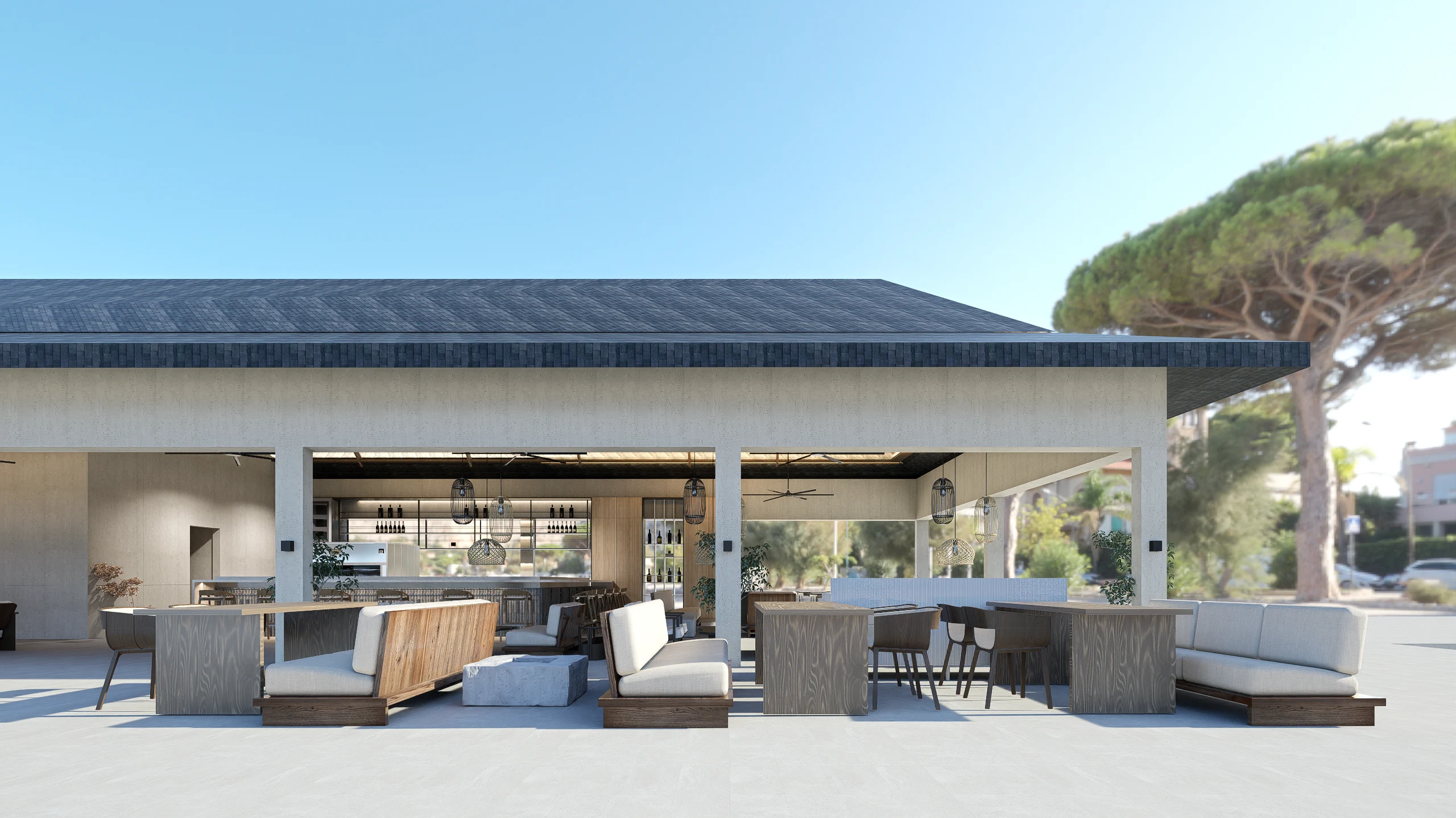 Outdoor modern bar or lounge with wooden tables, cushioned seating, and a covered open-air seating area under a pitched roof, with hanging pendant lights.