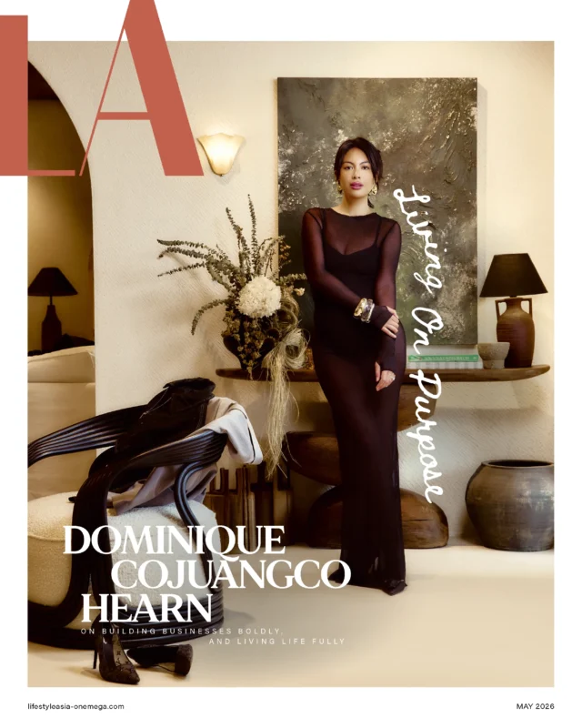 Fashion magazine cover featuring a woman in a black sheer dress standing in a stylish living room with a large abstract painting behind her and bold white title text across the image.