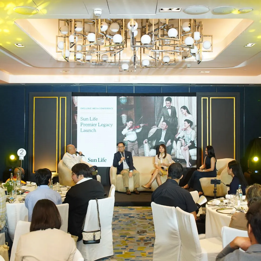Panel of four speakers on a stage at a Sun Life Premier Legacy Launch event, with a large backdrop and audience seated at round tables in front.