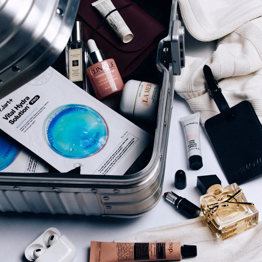 travel kit Travel-Sized Beauty Items To Take On Your Next Trip Original Compact Case in Silver by RIMOWA; Dermask Vital Hydra Solution by DR. JART; English Pear & Freesia 30ml Cologne by JO MALONE LONDON; Lip Balm by LE LABO; Moisture Surge Active Glow Serum 30m by CLINIQUE; Crème de la Mer by LA MER; Strobe Beam Liquid Blush by MAC; Leather Luggage Tag in Black by RIMOWA; Libre Eau De Parfum 30ml by YSL; Resurrection Aromatique Hand Balm by AESOP.